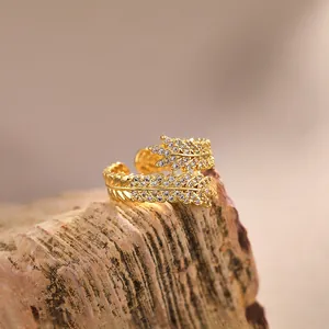 Adjustable gold plated ring featuring interlocking feather motifs with pavé cubic zirconia