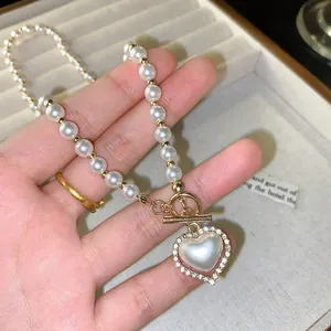 Macro shot of camellia pearl necklace featuring heart pendant with micro-inlaid rhinestones