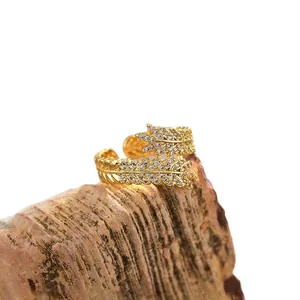 Elegant gold wheat leaf open ring with zircon inlay on a natural rock display