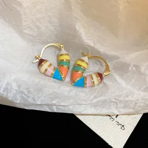 Rainbow enamel heart earrings in gold plated finish on minimalist white background