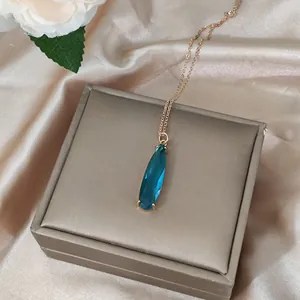 16K gold teardrop teal crystal necklace displayed in a luxury champagne jewelry gift box
