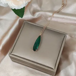 Detailed view of emerald drop pendant in 16K gold setting with premium gift box