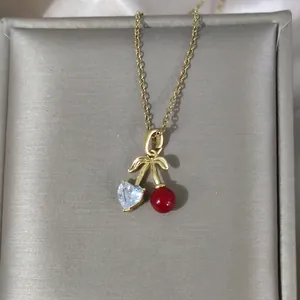 Makro-Detail einer Kirsch-Halskette mit roter Perle und herzförmigem Zirkonia-Kristall