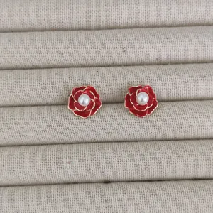 Elegant red camellia stud earrings with gold edges and central white pearl accent