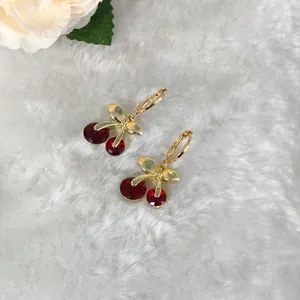 Detailansicht der Kirschohrringe mit goldenen Blättern und roten Kristallperlen