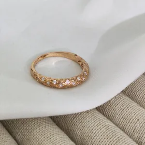 Macro shot of rose gold ring with woven texture and sparkling round zircon stones