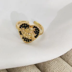 Detailed view of vintage gold heart ring featuring angel relief and black pavé stones