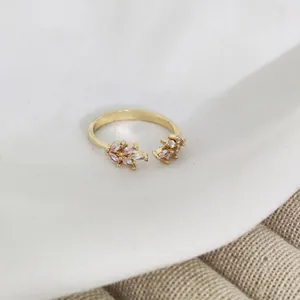 Detail of adjustable gold ring featuring marquise-cut pink zircon flower clusters