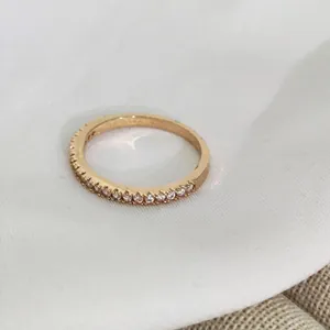Macro detail of gold eternity ring with half-circle micro-paved cubic zirconia