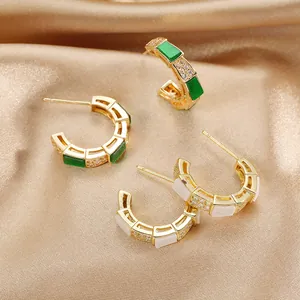 Orecchini a forma di C placcati in oro con dettagli in smalto verde smeraldo e bianco