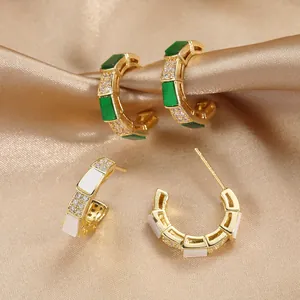 Orecchini a C di lusso con accenti verde smeraldo e zirconi scintillanti su raso dorato