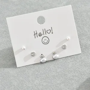 Set di tre paia di orecchini d'argento con perle e zirconi a cuore su cartoncino bianco