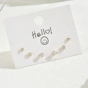 Detail of minimalist gold-plated stud earrings set with sparkling cubic zirconia stones