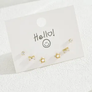 Set of 3 pairs of gold bow earrings with pearls and crystals on white display card