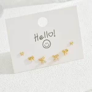 Set of six gold bow stud earrings with cubic zirconia on a white display card