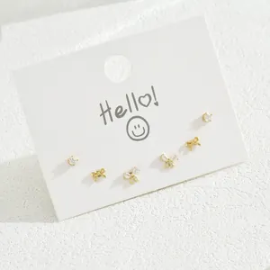 Elegant 6-piece gold earring set with bow designs and zircon studs on a white card