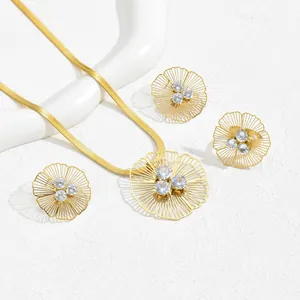 Elegant gold flower jewelry set with hollow petals and crystals for women on white surface