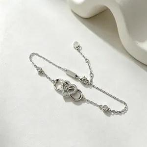 Polished 925 sterling silver infinity heart bracelet with zircon stones on stone background
