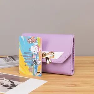 Macro detail of purple tri-fold wallet featuring gold bow clasp and V-shaped stitching