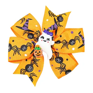Detail of Halloween bow hair clip featuring orange ribbon with ghost and pumpkin motifs
