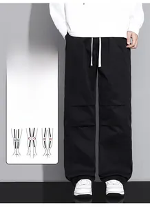 Detail of black loose-fit cargo pants with adjustable drawstring and knee seam details