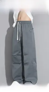 Detail of dark gray cargo pants with elastic waist drawstring and pleated knee design