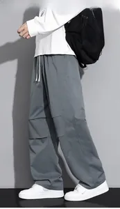 Detail of grey cargo pants showing drawstring waist and knee paneling design