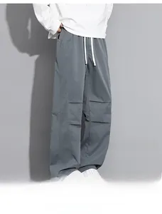 Detail of grey cargo pants featuring relaxed straight fit and white drawstring waist cord