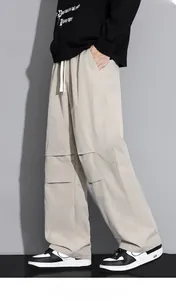 Detail of loose fit cargo pants showing knee pleats and stitching in light khaki