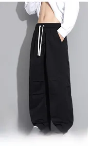 Detail of men's black wide-leg cargo pants with elastic waist and white drawstring