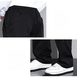 Detail view of the elastic waistband and fashion drawstring on black cargo pants