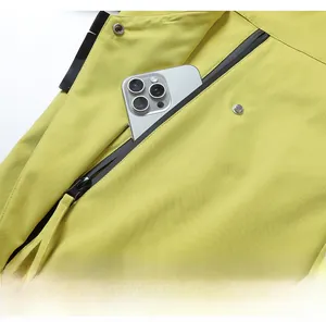 Détail de la veste d'extérieur jaune avec poche zippée imperméable et bouton-pression