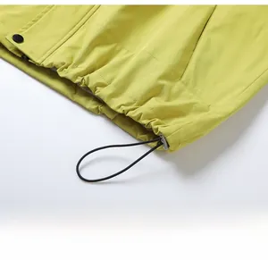 Détail de l'ourlet à cordon ajustable et tissu coupe-vent sur la veste verte