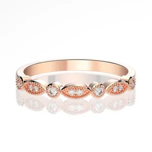 Detail of rose gold band with marquise shapes and milgrain edges set with small diamonds