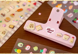 Close-up detail of cute 3D puffy food stickers and a pink heart club stationery clip.