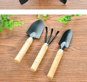 Detailed view of 3-piece mini garden tools with black metal heads and smooth wood handles