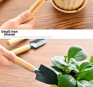 Close-up of garden hand shovel with wooden handle and black iron head for potting soil