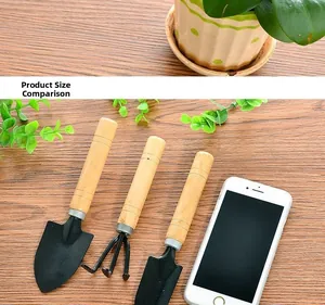 Close-up of mini 3-piece gardening set with wooden handles and black metal heads