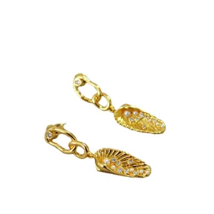 Golden chain link earrings featuring shell pendants with white pearls and sparkling zircons