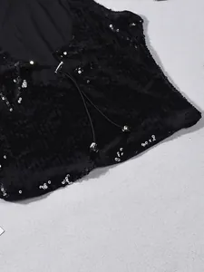 Détail du gilet à paillettes noires avec cordon de serrage et perles métalliques
