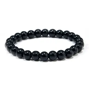Close-up of polished black onyx beads on a minimalist punk style bracelet for men