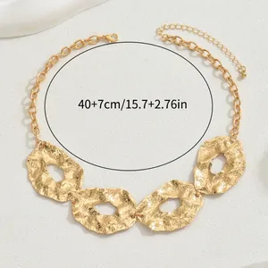 Golden irregular geometric link necklace with hammered metal texture and toggle clasp