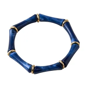 Pulsera elástica de acrílico azul marmoleado estilo bambú con anillos de metal dorado