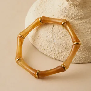 Pulsera vintage de acrílico estilo bambú con textura de ámbar y aros de metal dorado