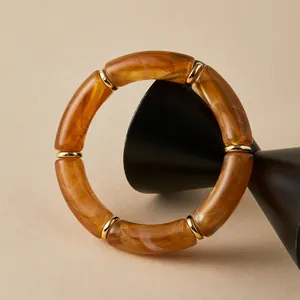 Bracciale bohémien in acrilico leopardato con anelli dorati su supporto nero