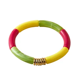 Colorful resin bamboo tube bracelet in yellow pink and green with gold metal accents