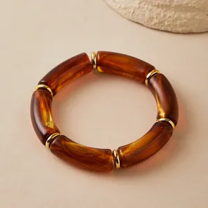 Dettaglio del bracciale bohémien in resina ambrata con anelli dorati e texture leopard
