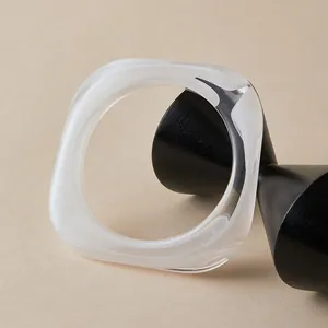 Detailed view of irregular square resin bangle with translucent white marble texture