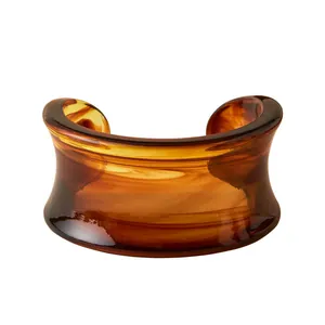 Bohemian acrylic cuff bracelet with amber tortoise pattern on white background