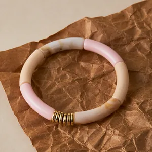 Detail of bohemian acrylic tube bracelet with pink and marble beads on brown paper